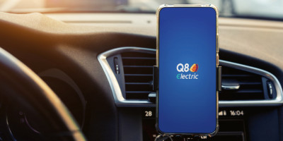 Logo Q8 électrique en grand sur fond bleu sur un smartphone sur un support GPS